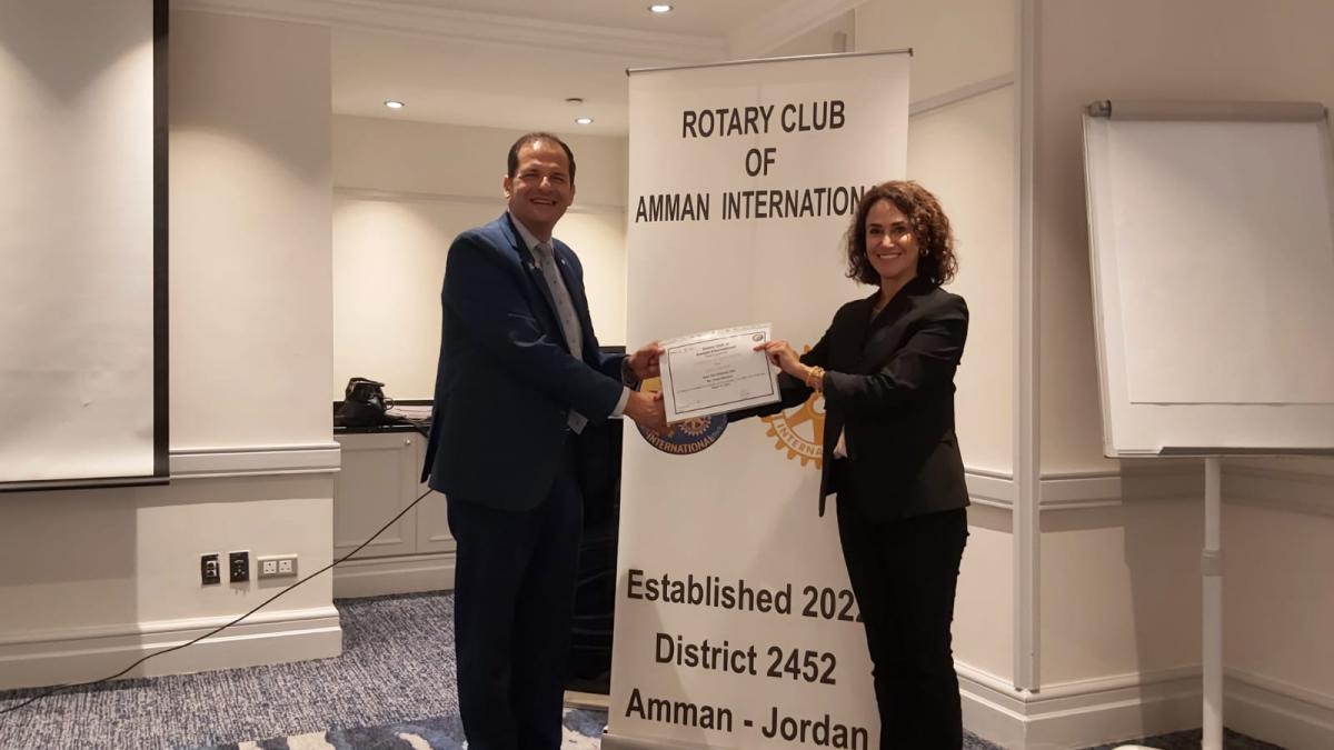 President Samuel Kakish presents speaker Diala Khamra with appreciation certificate