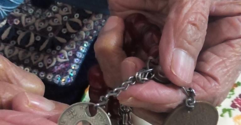 عملة فلسطينة بيد لاجئة مسنة بالوحدات