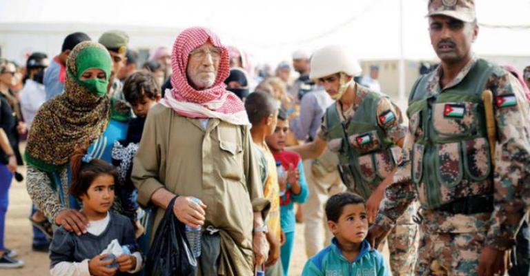 جندي اردني يستقبل لاجئين سوريين-ارشيفية