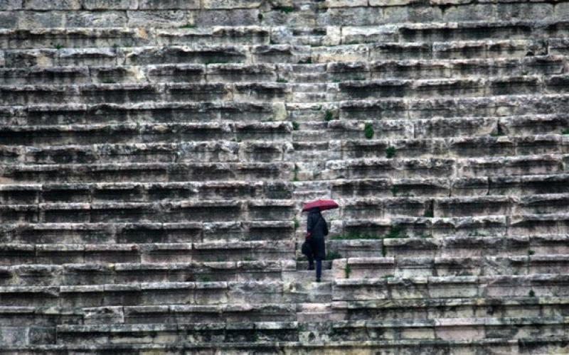 المدرج الروماني، صعوداً تحت المطر- عدسة حمزة مزرعاوي/ فيسبوك 