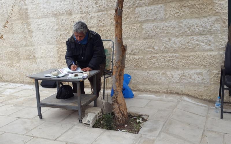 كاتب الاستدعاءات.. طاولة ومظلة والرزق على الله