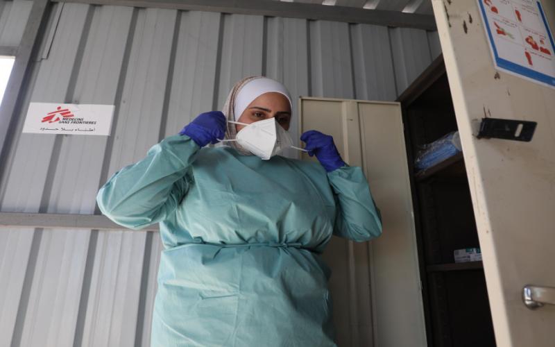 براءة مازن، ممرضة في منظمة أطباء بلا حدود في مركز علاج كوفيد-19 في مخيم الزعتري للاجئين، ترتدي ثوبا وقائيا قبل التعامل مع مرضى مصابين بالفيروس. 21/10/2020 (محمد سنباني/ منظمة أطباء بلا حدود)